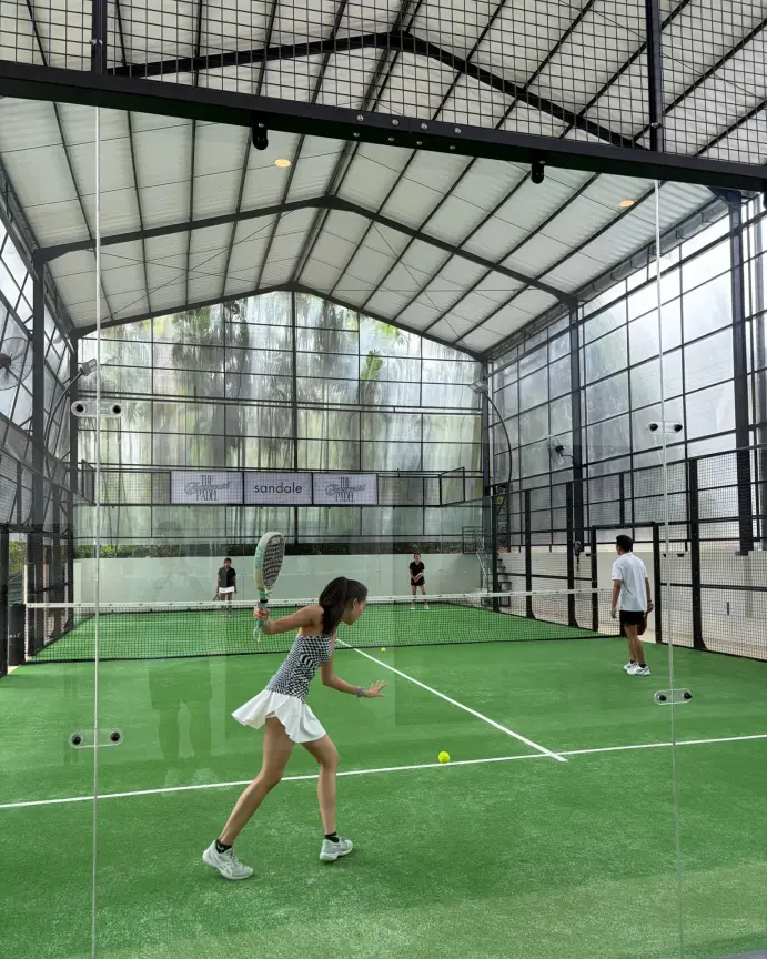 A player hitting a forehand on the green court